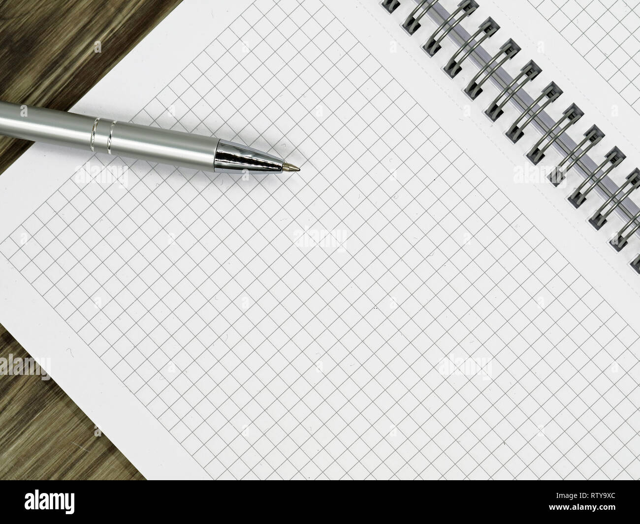 close up of blank notebook and a pen on wooden office desk with copy space Stock Photo