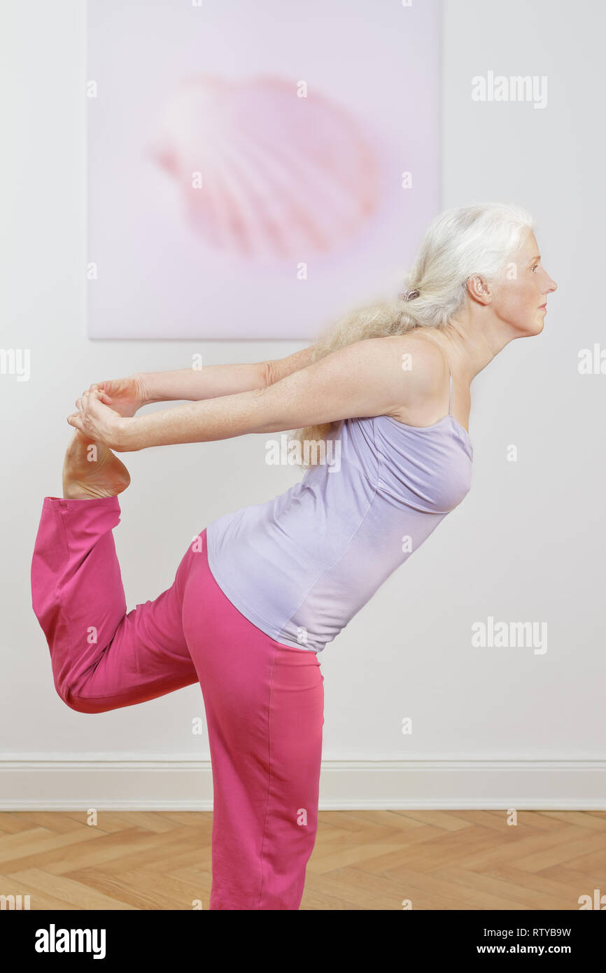 Senior woman with lang gray hair doing yoga exercise at home in front shell picture, intro Stock Photo - Alamy