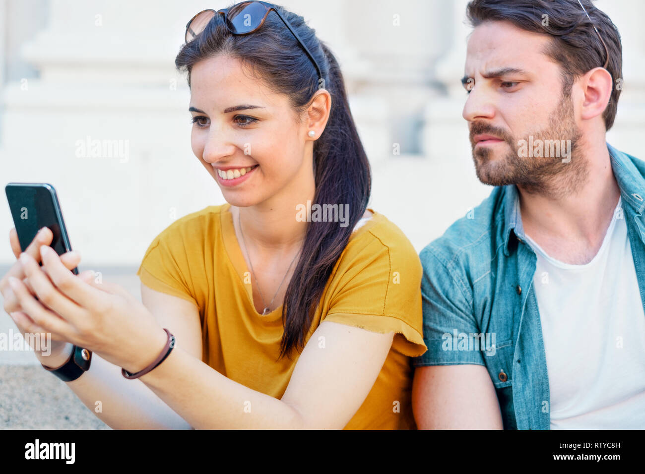 Jealous boyfriend spying girlfriend phone message Stock Photo