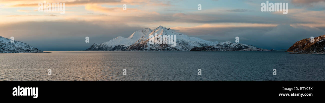 Panoramic view of the snowy island Vengsoya close to arctic town Tromso during sunset, Norway Stock Photo
