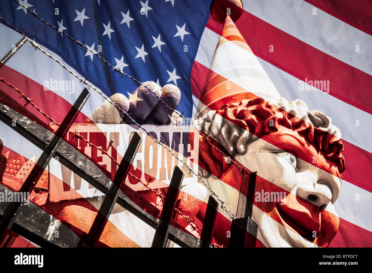 Clown holding welcome sign behind razor wire fence: USA, United States of America immigration concept image. Stock Photo