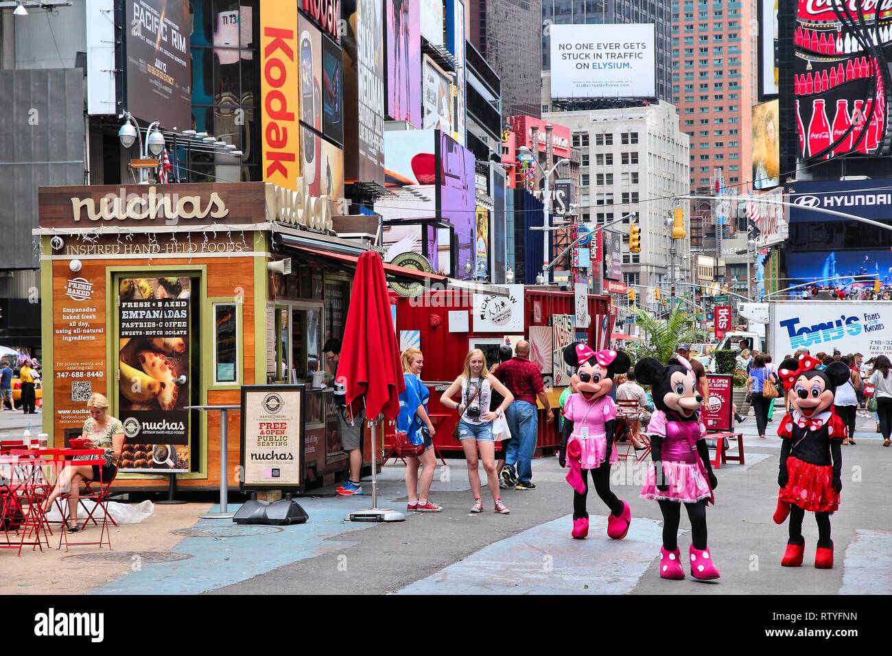 NEW YORK, USA - JULY 3, 2013: People visit Times Square in New York. Times Square is one of most recognized landmarks in the USA. More than 300,000 pe Stock Photo