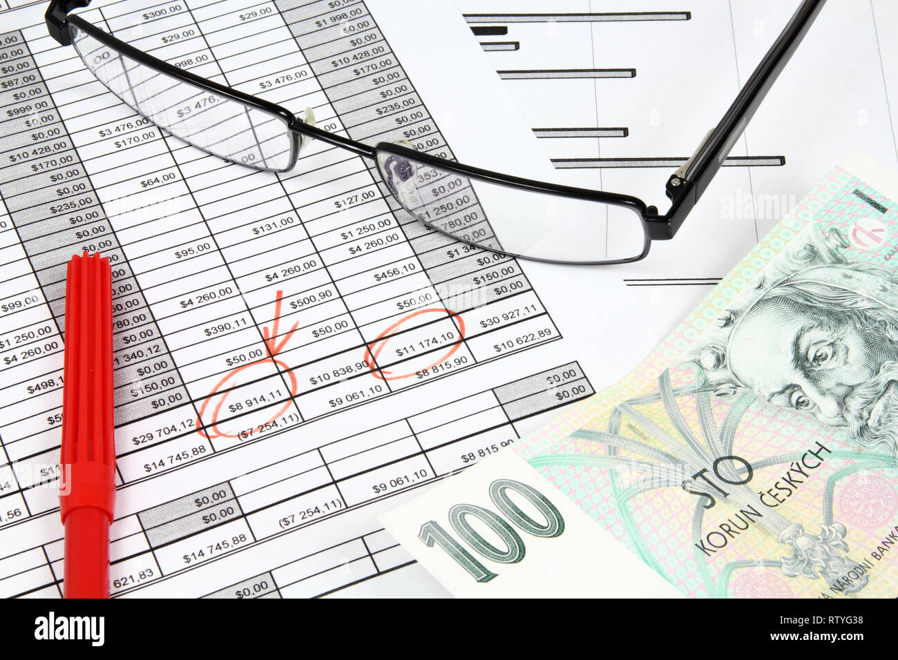 Business composition. Financial analysis - income statement, red marker, glasses and Czech koruna money. Stock Photo