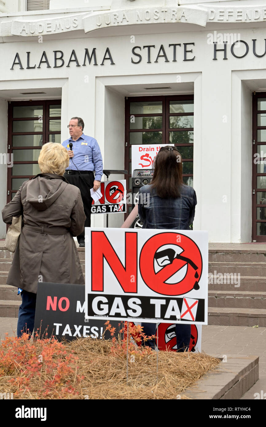 People listen to a speaker protesting taxes or a gas tax with signs against more taxes at the Alabama State House in Montgomery Alabama, USA. Stock Photo