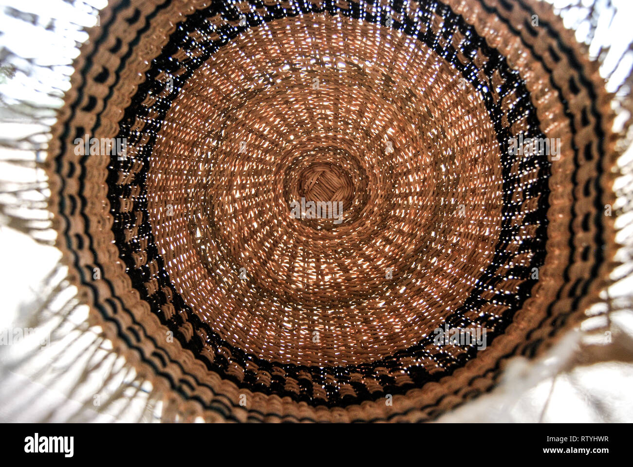 A photo of a half finished handwoven Bolga market basket made of colored elephant grass (vera veta). Stock Photo