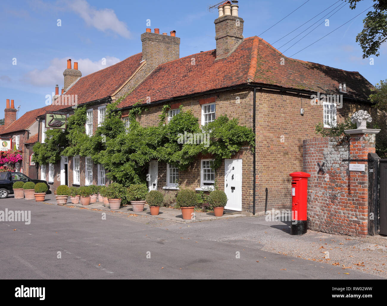 Traditional English Village Pub with red post box outside Stock Photo