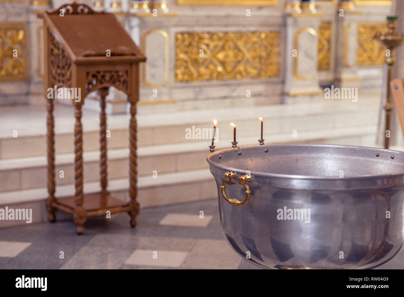 Christening ceremony in the Orthodox church, priest lighting candles at