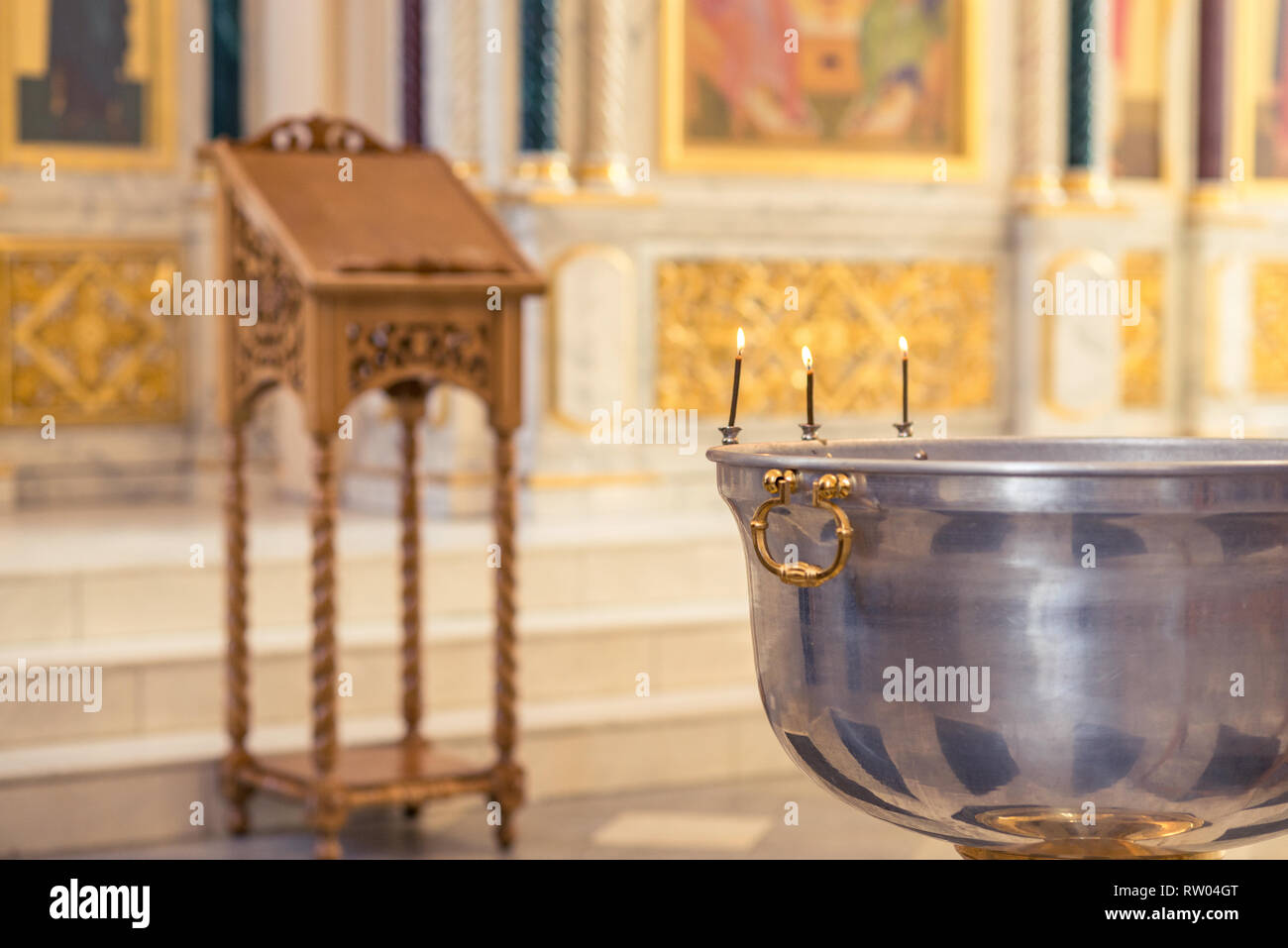 Christening ceremony in the Orthodox church, priest lighting candles at
