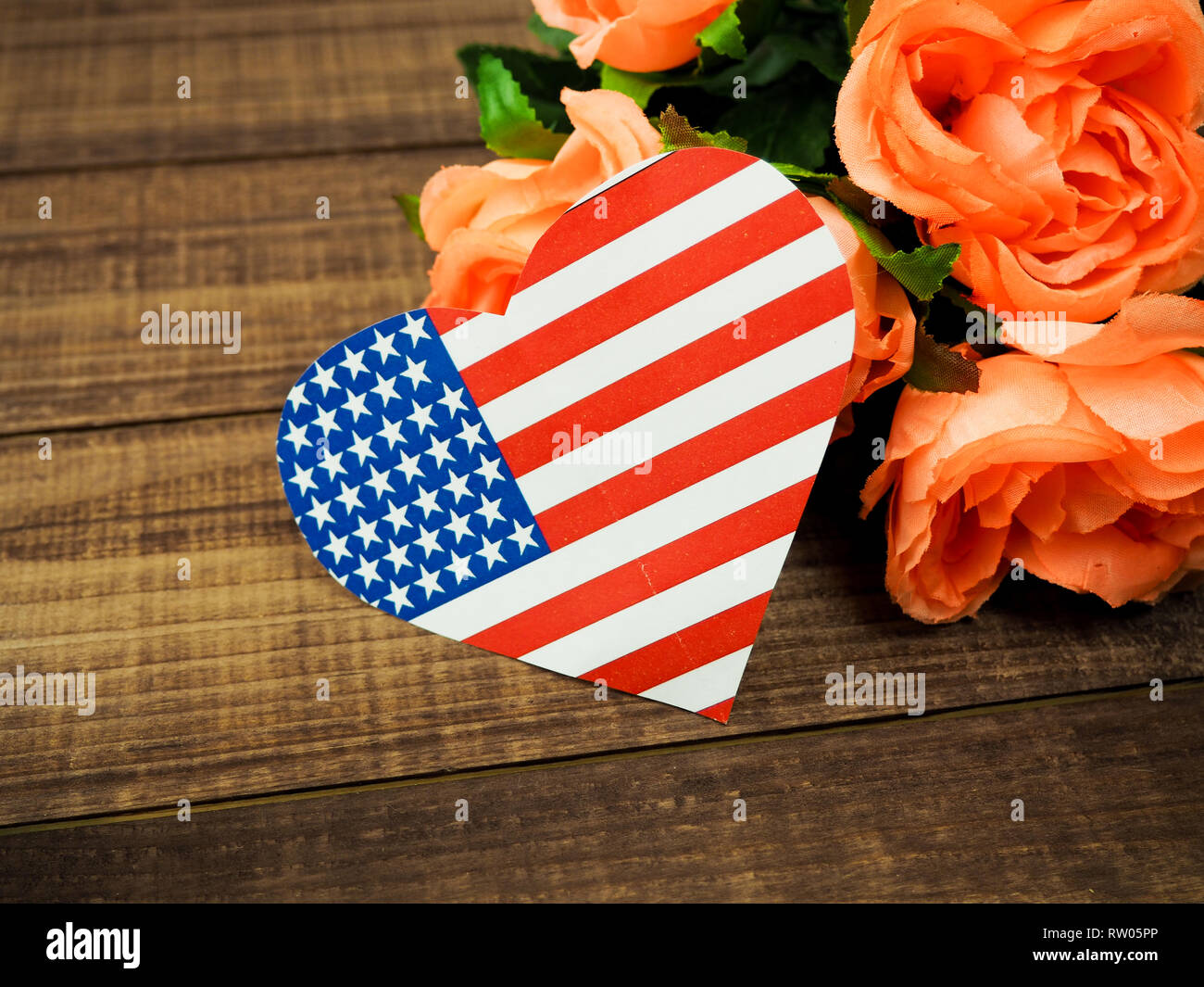 USA flag in the form of hearts and flowers on a wooden background. Stock Photo