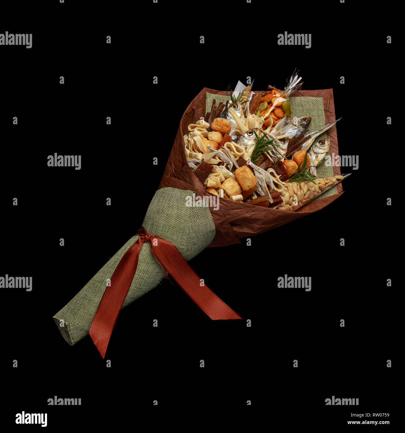 Unique bouquet consisting of dried salted fish, salted peanuts, crackers, dried bread and other beer snacks isolated on black background as male gift Stock Photo