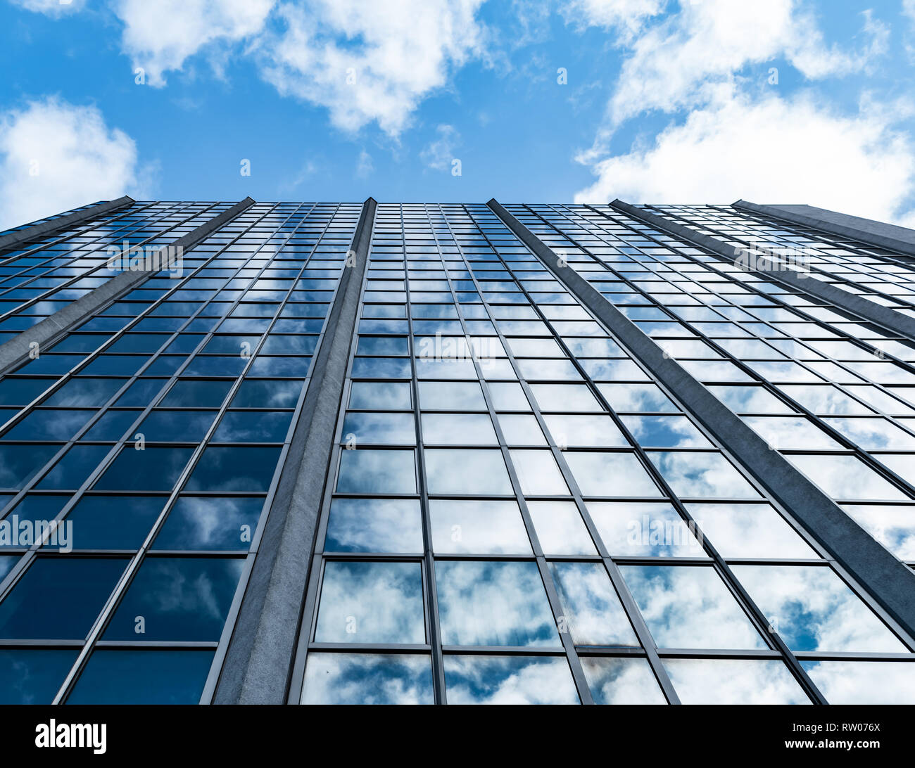 Cloudy sky reflecting in the windows of a big scenic office building in ...