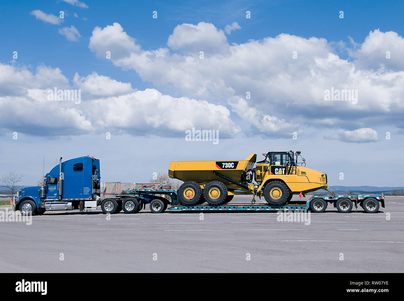 Caterpillar 730C Articulated Dump Truck Off-Highway Diesel on Flatbed Stock Photo