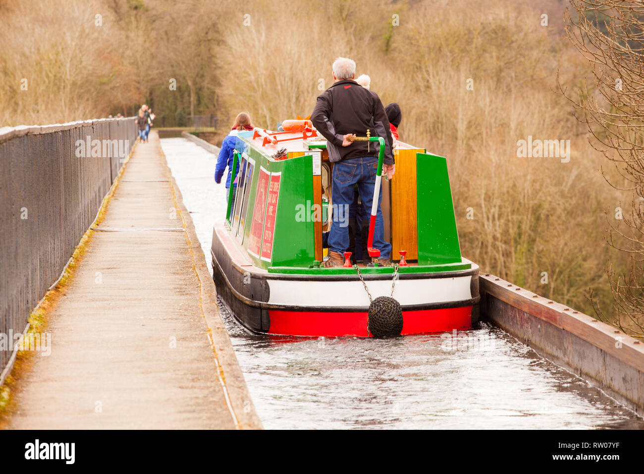 Man steering a narrow boat over the Pontcysyllte Aqueduct on the Llangollen canal  in North Wales above the river Dee built by Thomas Telford 1805 Stock Photo