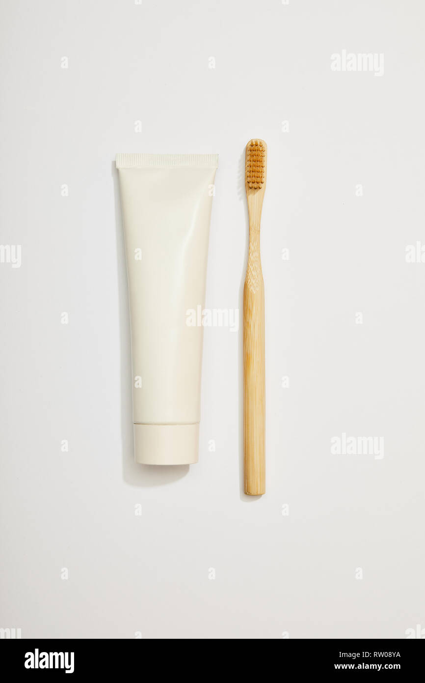 top view of bamboo toothpaste in tube and toothbrush on white ...