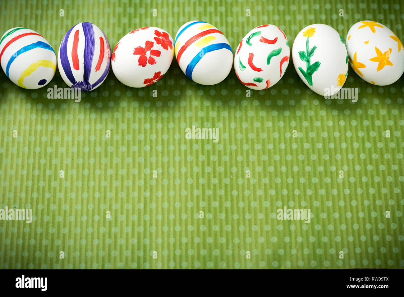 Easter eggs painted by hand on a beautiful green background in white peas. Festive background. Easter ideas. Space for text. Happy easter. Stock Photo