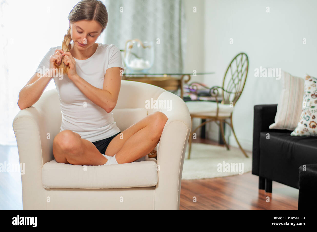 Beautiful Woman With Long Hair Weaving A Braid At Home Stock Photo