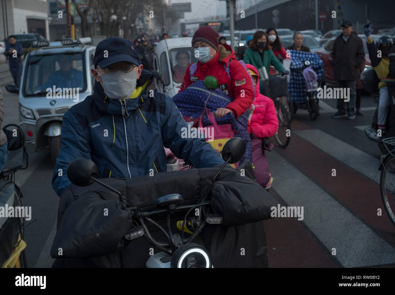 People wear masks in a day of Orange smog alert in Beijing, China.   04-Mar-2019 Stock Photo