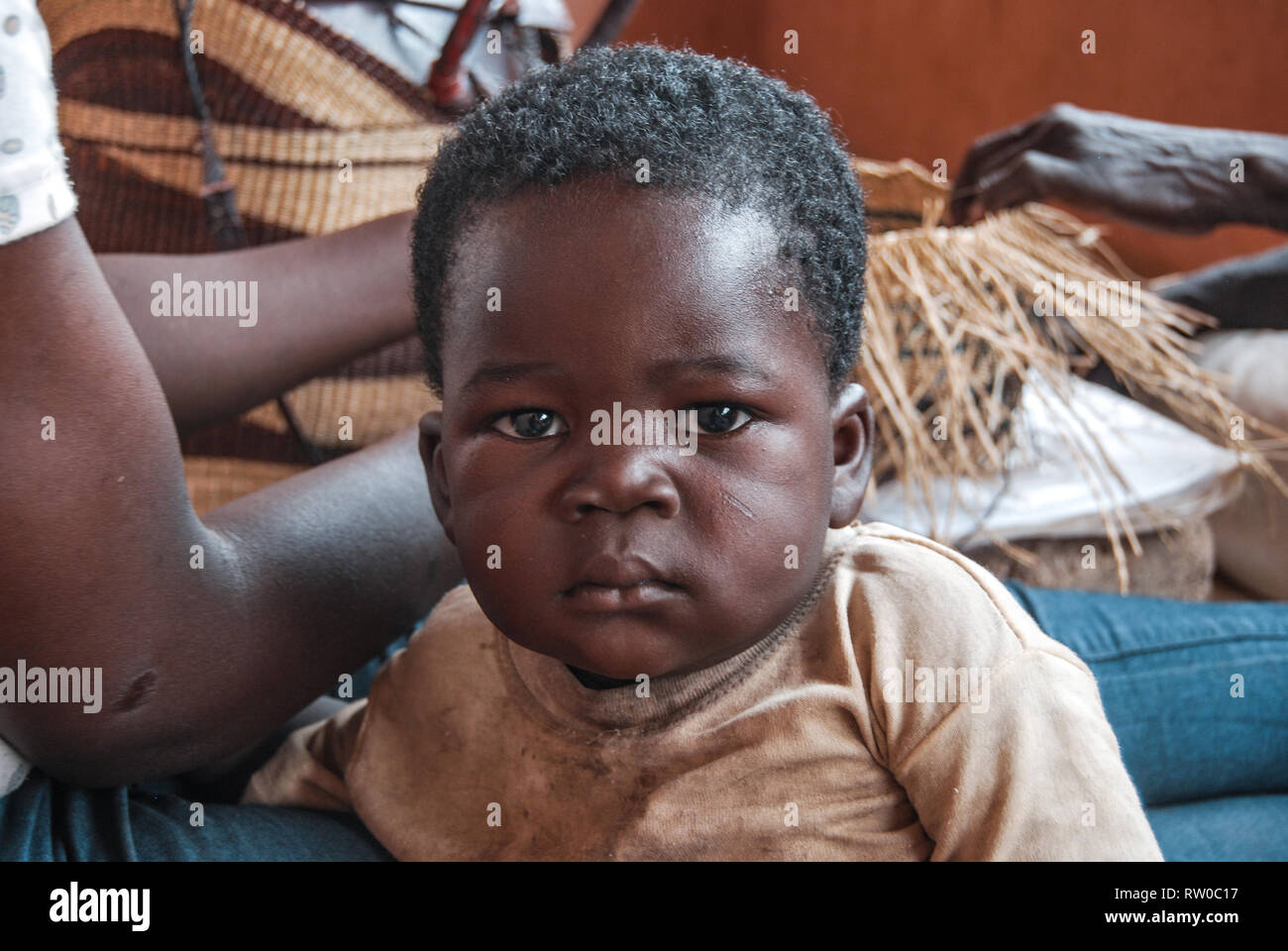A portrait of a serious looking young adorable Ghanaian boy toddler with tribal marking. Stock Photo