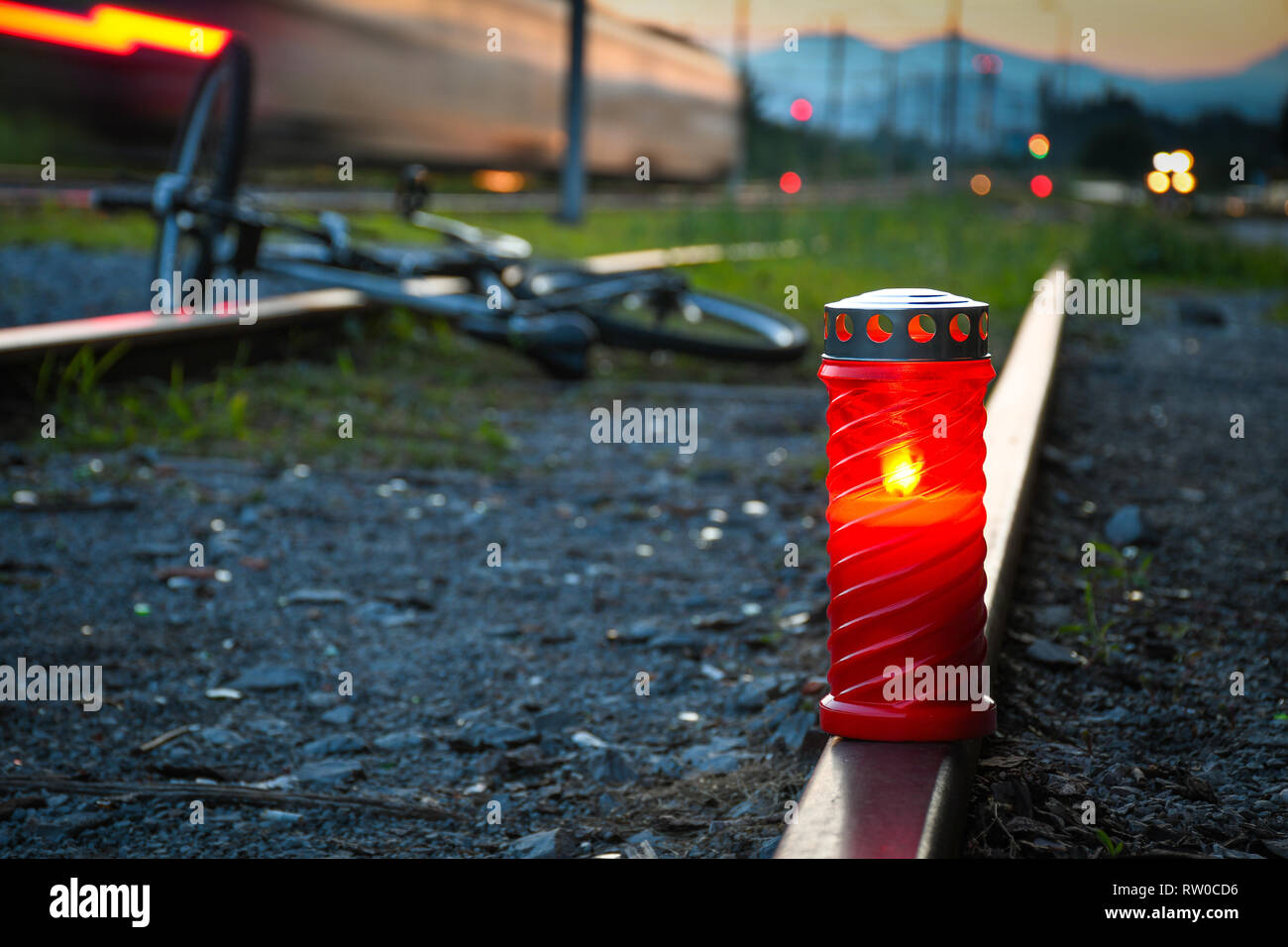 Fatal bicyclist and train crash accident when crossing rail road. Train accident with red candle and broken bicycle lying on the metal rail track Stock Photo