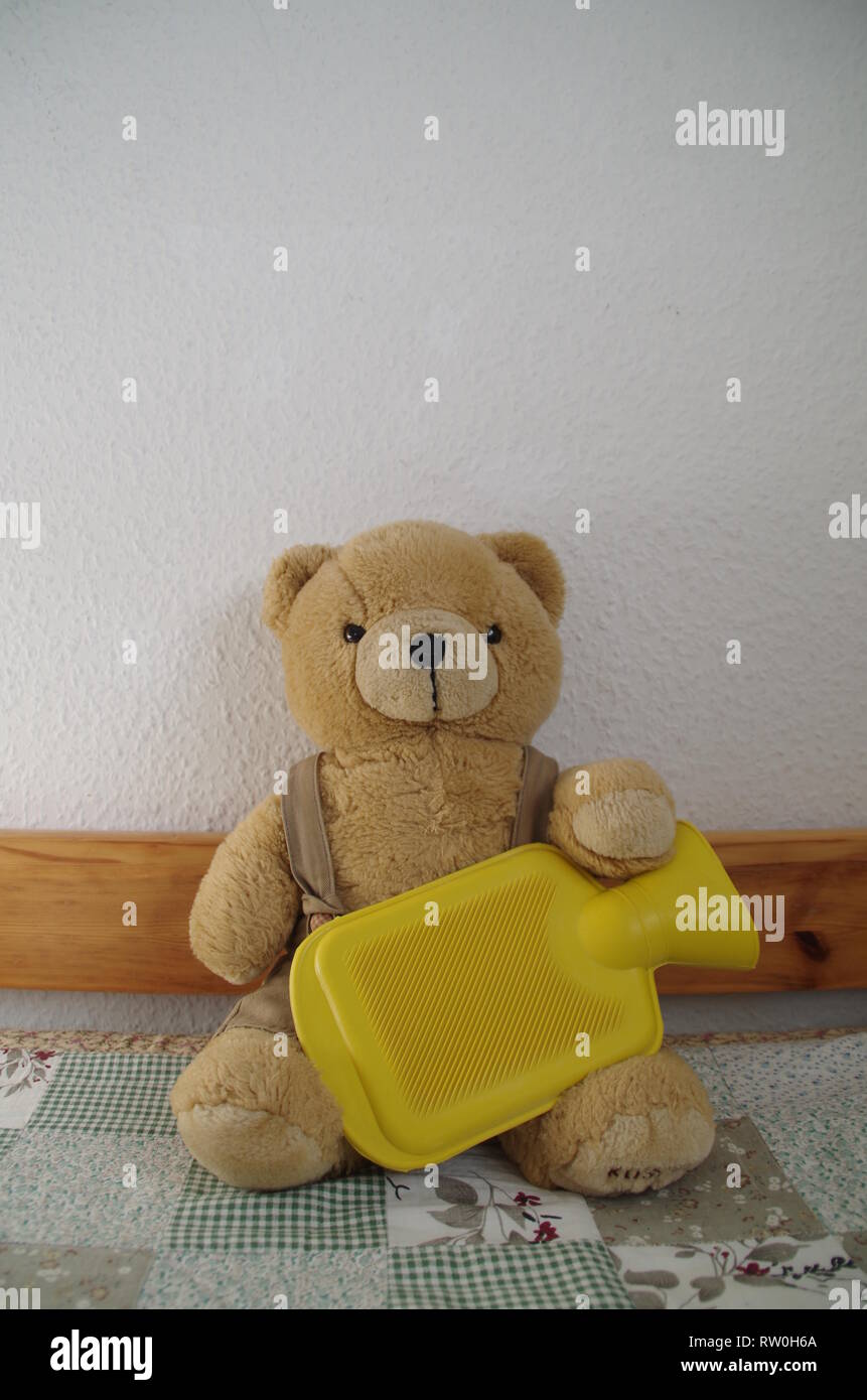 Stomach pain Teddy bear with yellow hot water bag Stock Photo Alamy