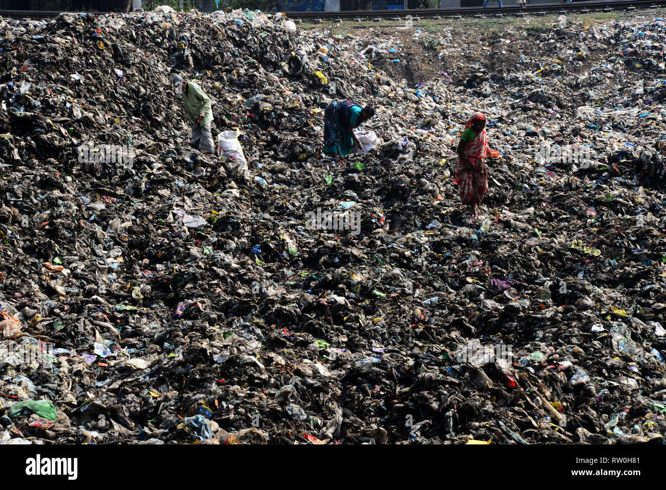 Bangladeshi poor people collect plastic pieces for sale in the waste