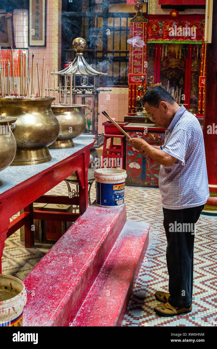 Sin Sze Si Ya Taoist Temple, Chinatown, Kuala Lumpur, Malaysia.  Worshiper Bowing with Joss Sticks.  Oldest Taoist temple in Kuala Lumpur (1864). Stock Photo