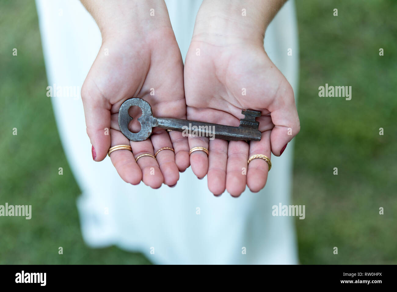 A vintage key in a woman's hands Stock Photo