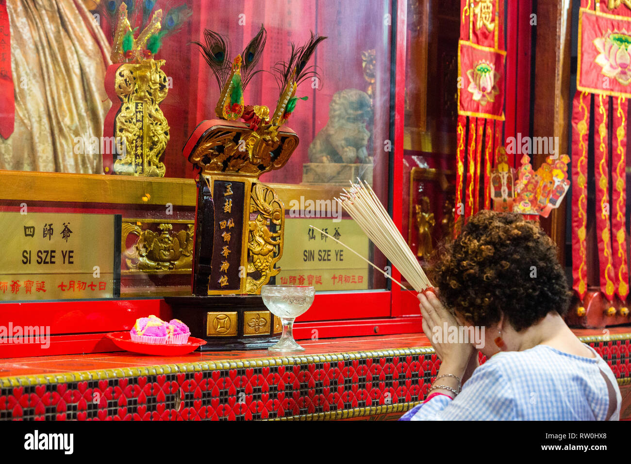 Sin Sze Si Ya Taoist Temple, Chinatown, Kuala Lumpur, Malaysia.  Worshiper Praying before Deities Si Sze Ye and Sin Sze Ye. Oldest Taoist temple in KL Stock Photo