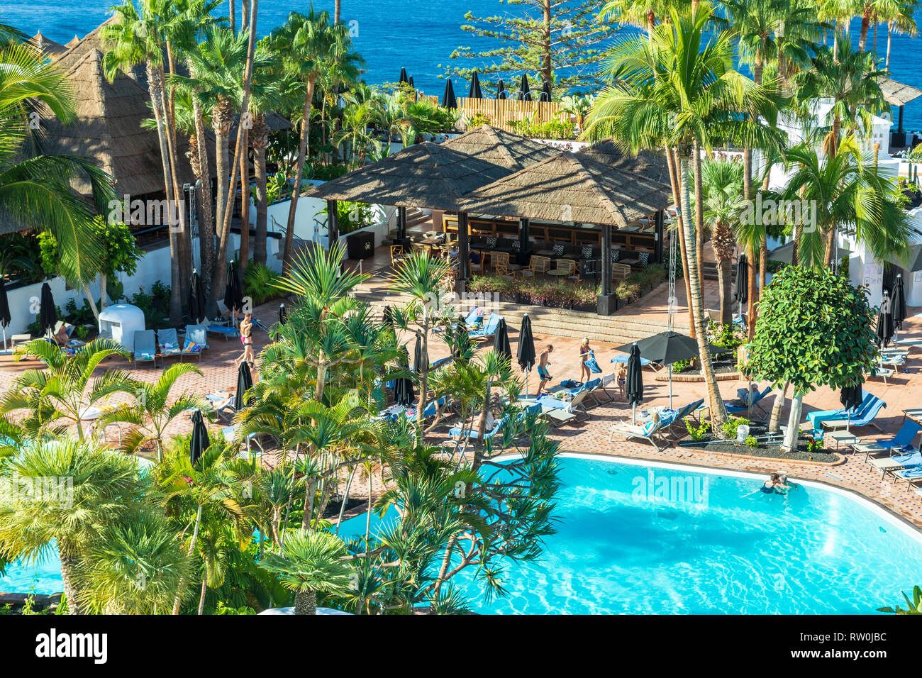Tenerife Costa Adeje luxury hotel.  Right by the sea the hotel pool is surrounded by palm trees. Stock Photo