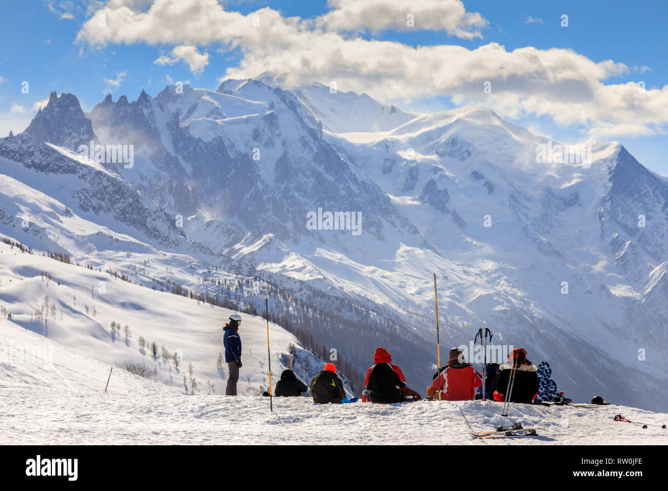 Family of skiers sitting down in front of Mont Blanc Stock Photo