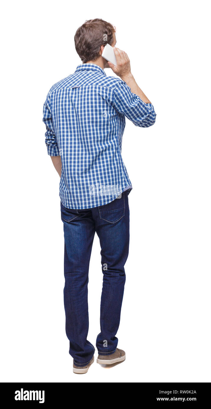 backview of man walking with a mobile phone. backside view of ...