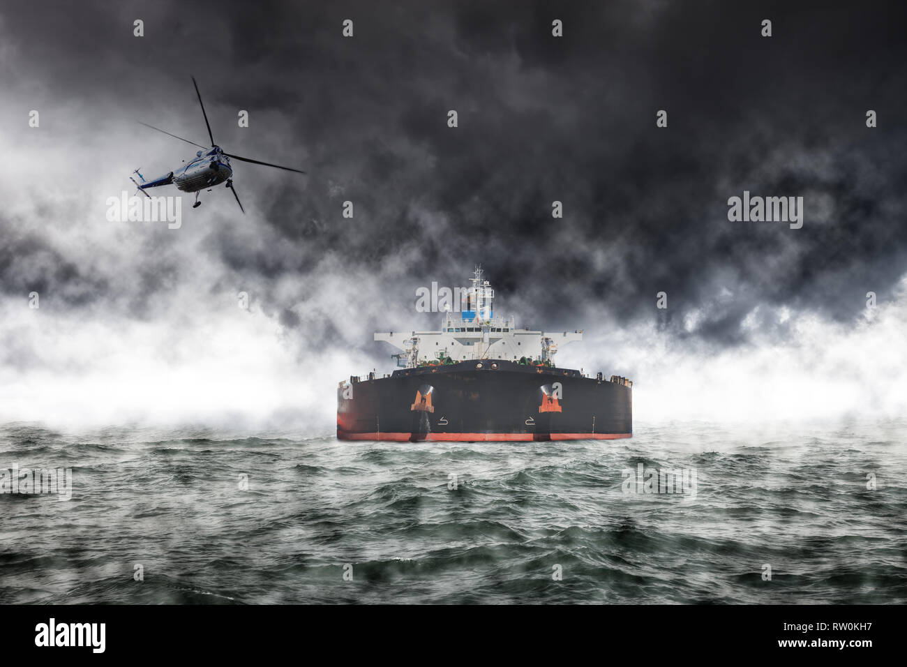 A helicopter rescue mission in difficult stormy weather at sea. Stock Photo