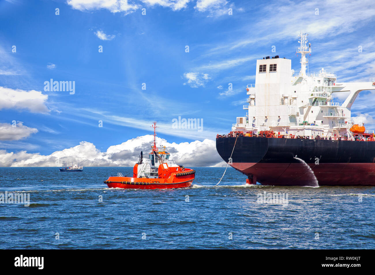 Tanker ship with escorting tug leaving port. Stock Photo