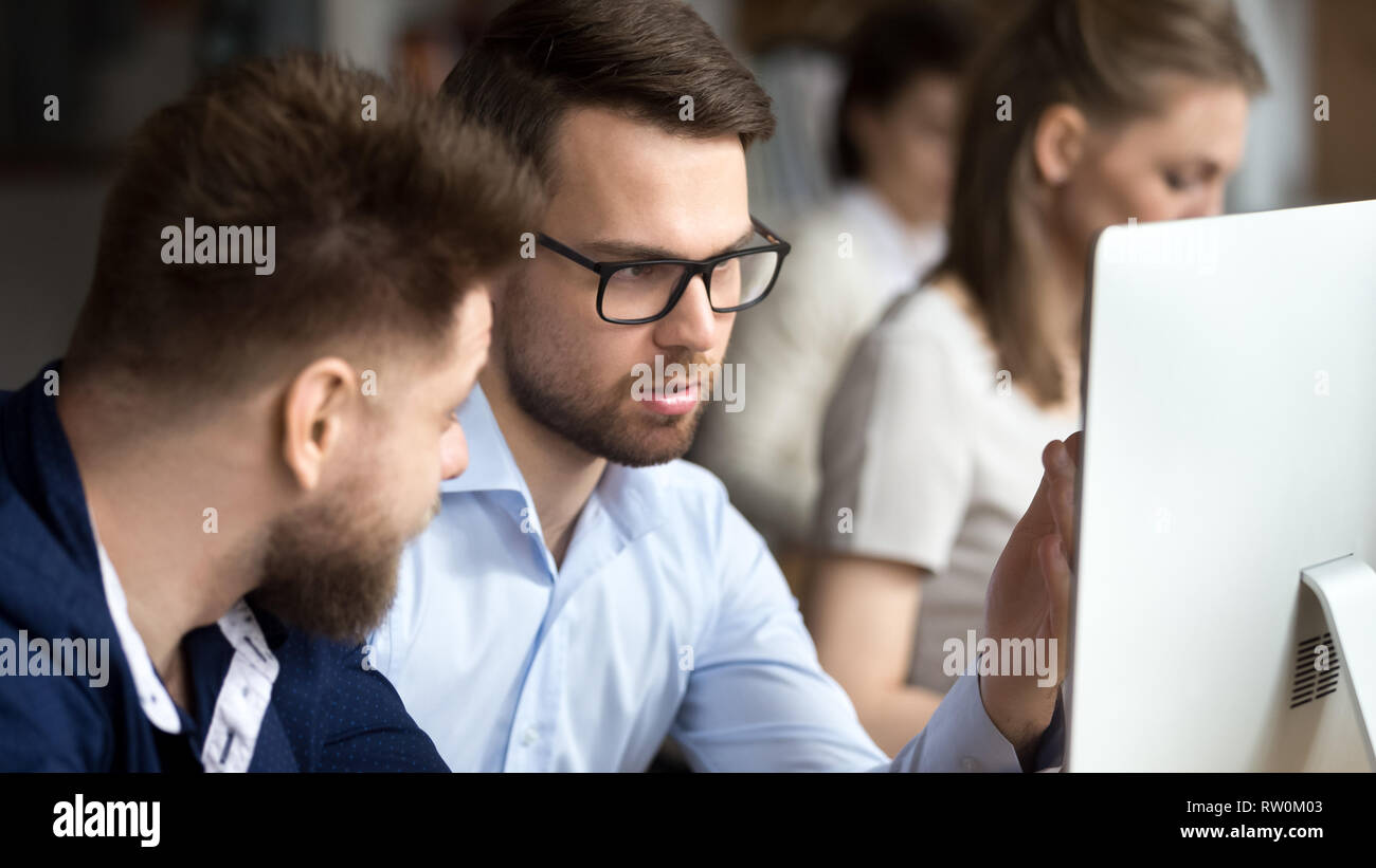 Businessmen sitting together in coworking with other business people Stock Photo
