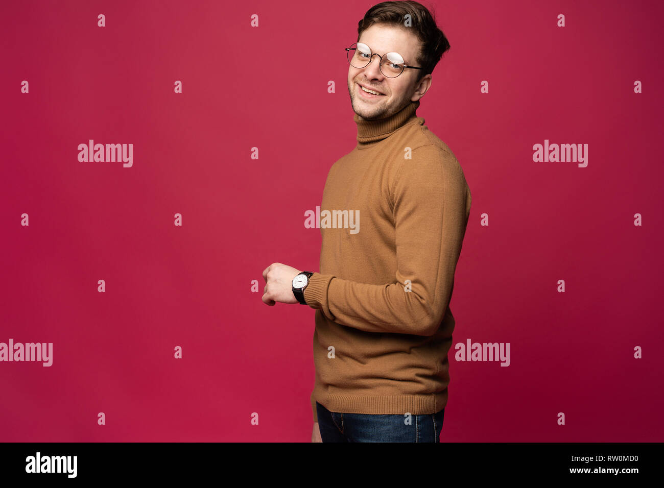 A confident young man in a studio, wearing glasses Stock Photo - Alamy