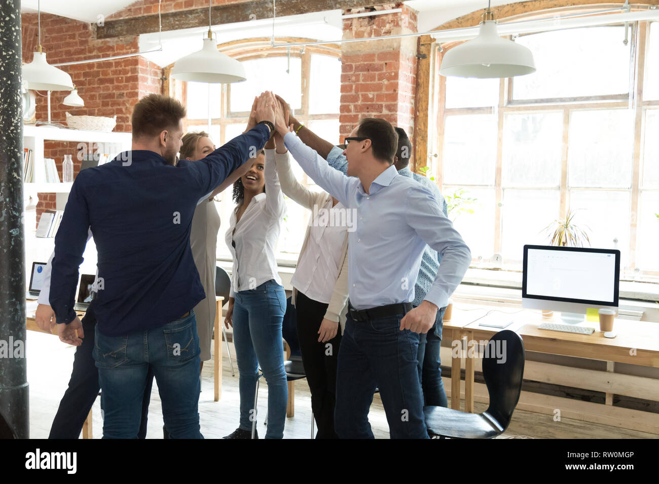 Businesspeople standing giving high five celebrating great results Stock Photo