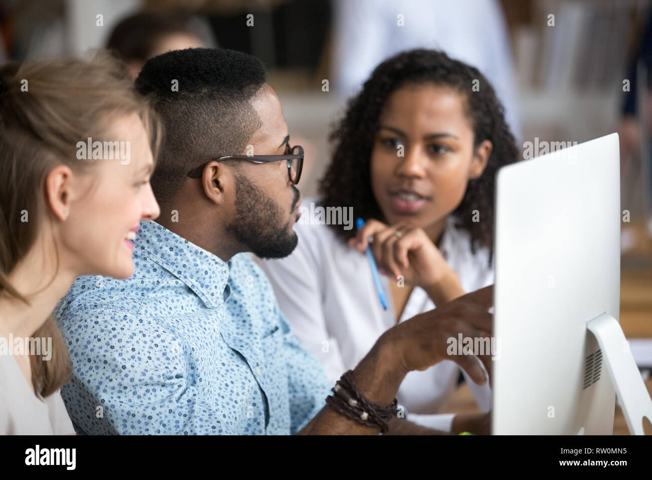 Black african male explains women interns corporate program Stock Photo