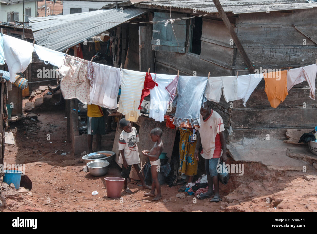A photo of a family drying clothes outside at their house in a slum suburb of the coastal town of Elmina, Ghana, West Africa Stock Photo