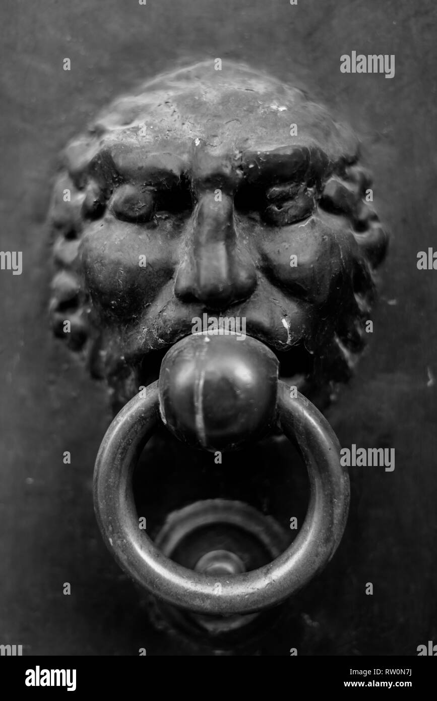 Close-up of an antique knocker on a dark background. Vertical view Stock Photo