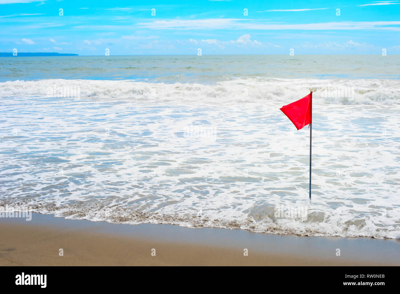 Waving red flag at the seashore, Bali, Indonesia Stock Photo