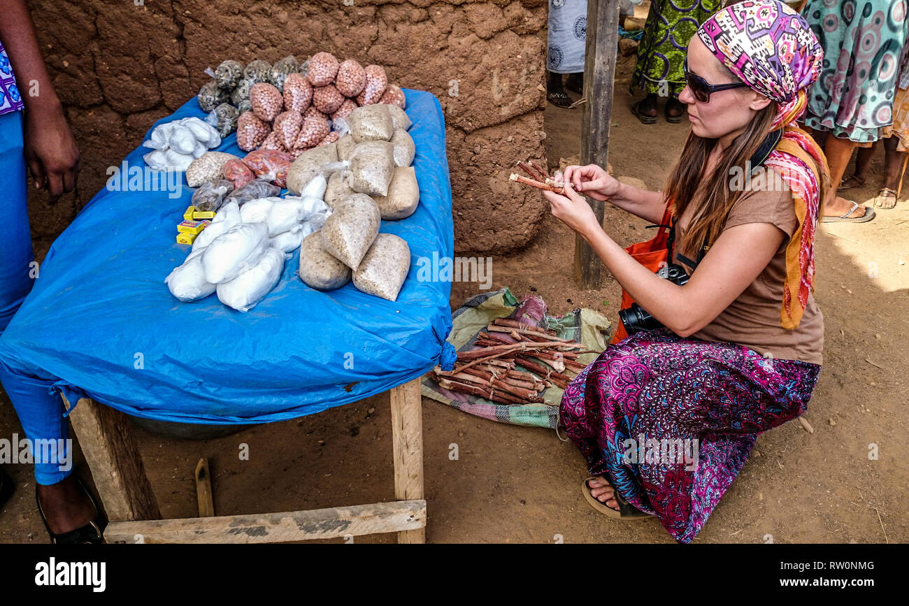 A European tourist inspecting local spices sold at the farmer's market in Ghanaian village of Kongo, West Africa Stock Photo
