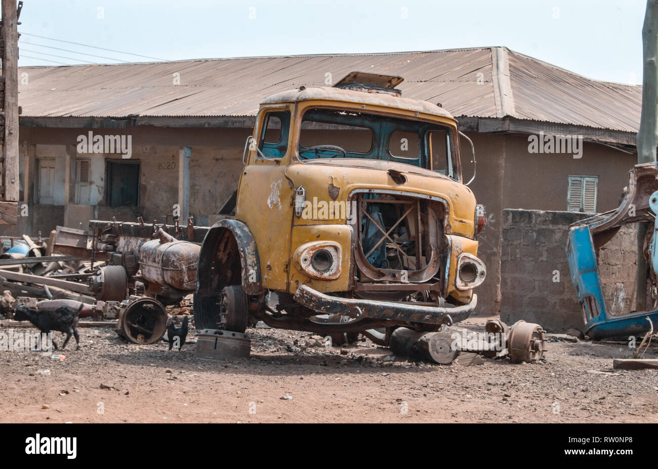 A wreckage of a yellow old truck left at a street in Bolgatanga, Ghana, West Africa Stock Photo