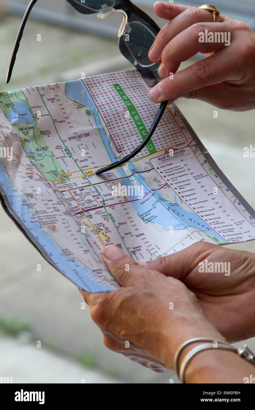 A couple of tourists view a map of Manhattan, New York City, USA in order to get around the city. Stock Photo