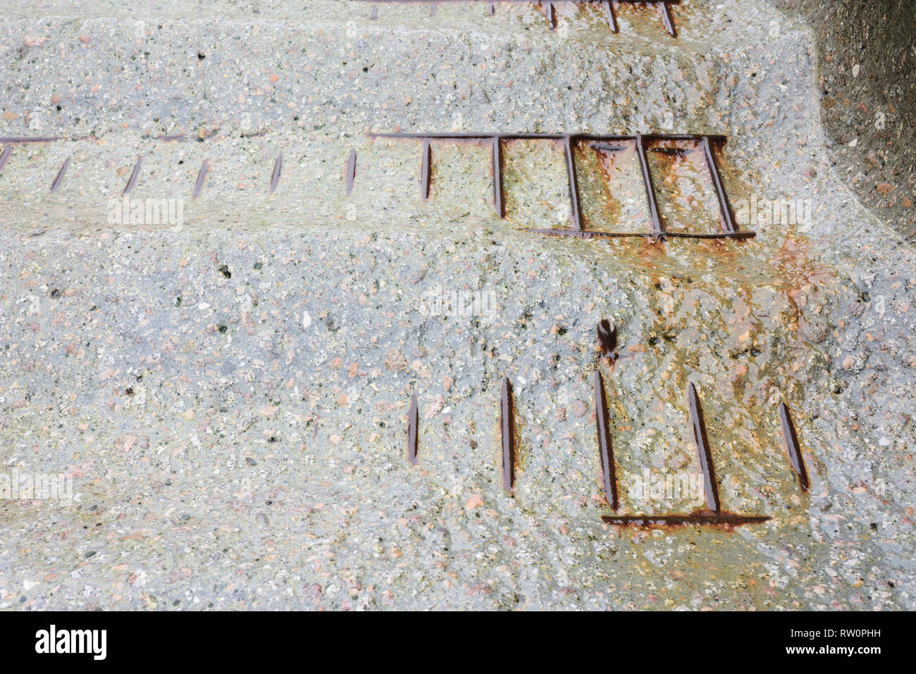 Worn reinforced concrete steps worn smooth with steel reinforcing mesh, rebar exposed, damaged