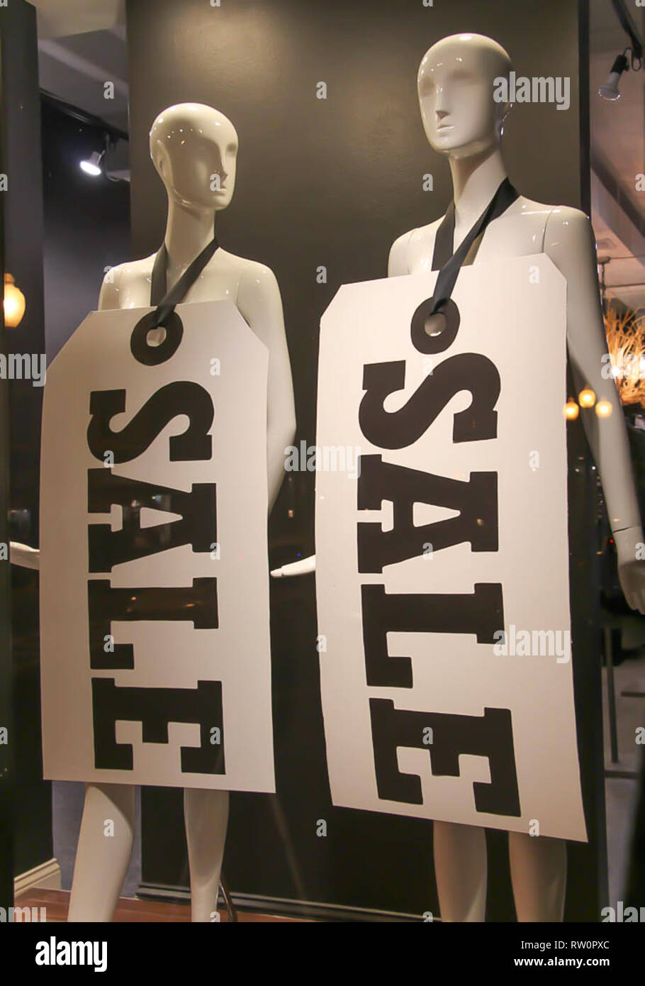 Mannequin Signs black and white sale signs hung on plain white mannequins in a shop ...