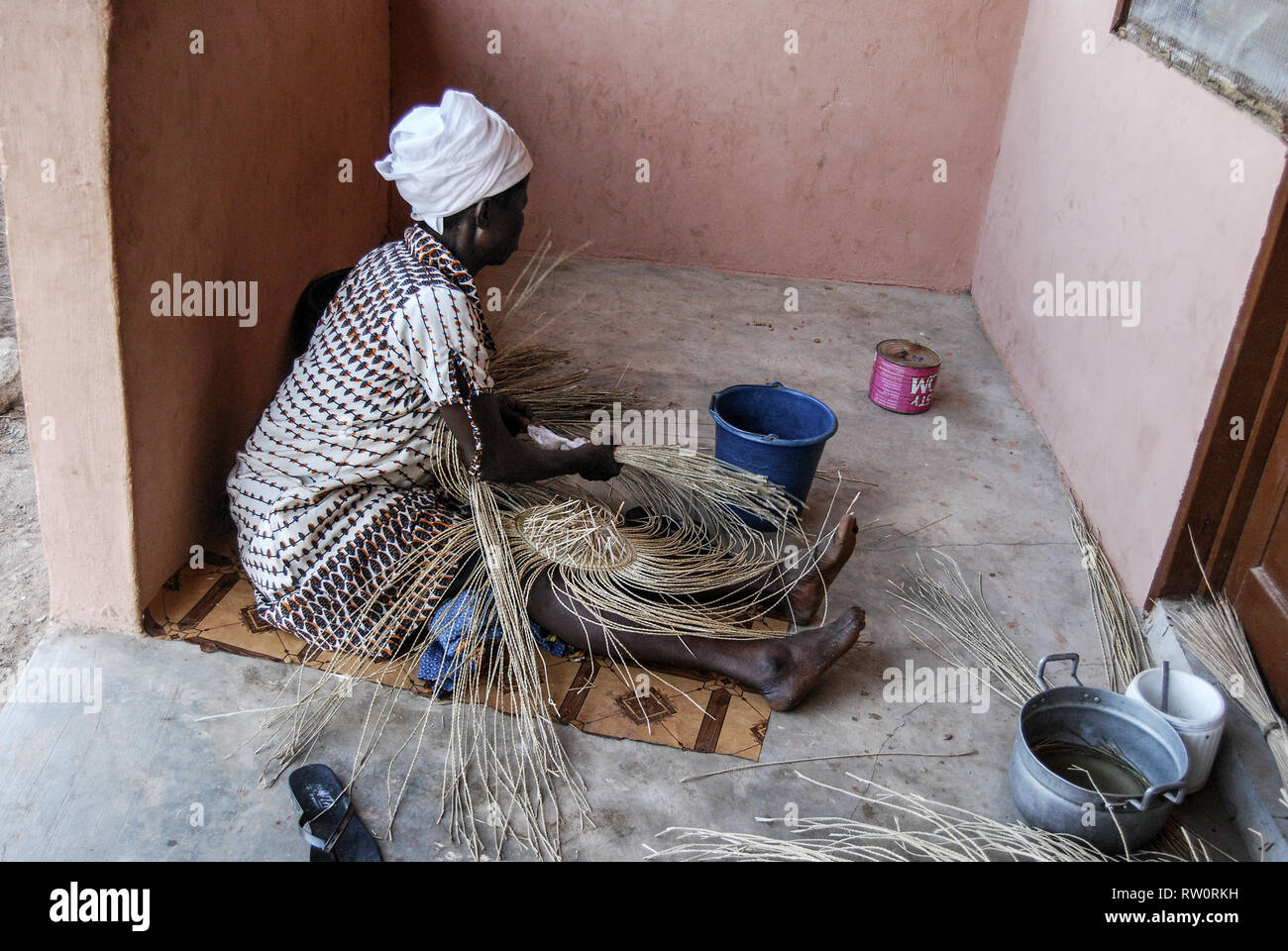 A photo of a local Ghanaian woman weaving the famous decorative and beautiful Bolga market basket. Stock Photo