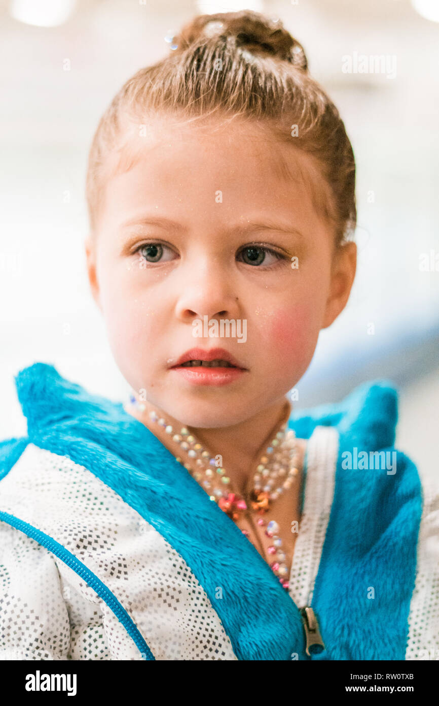 Little girl practicing for figure skating competition on indoor