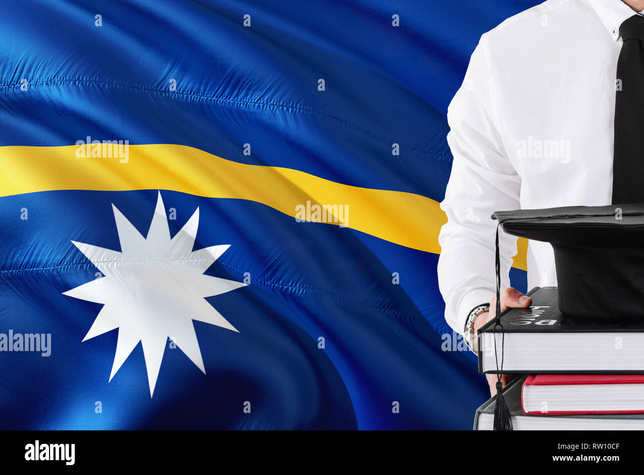 Successful Nauruan student education concept. Holding books and graduation cap over Nauru flag background. Stock Photo