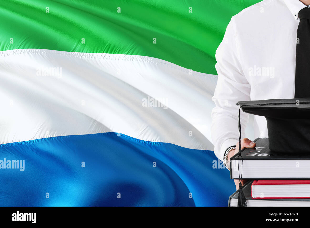 Successful student education concept. Holding books and graduation cap over  Sierra Leone flag background Stock Photo - Alamy