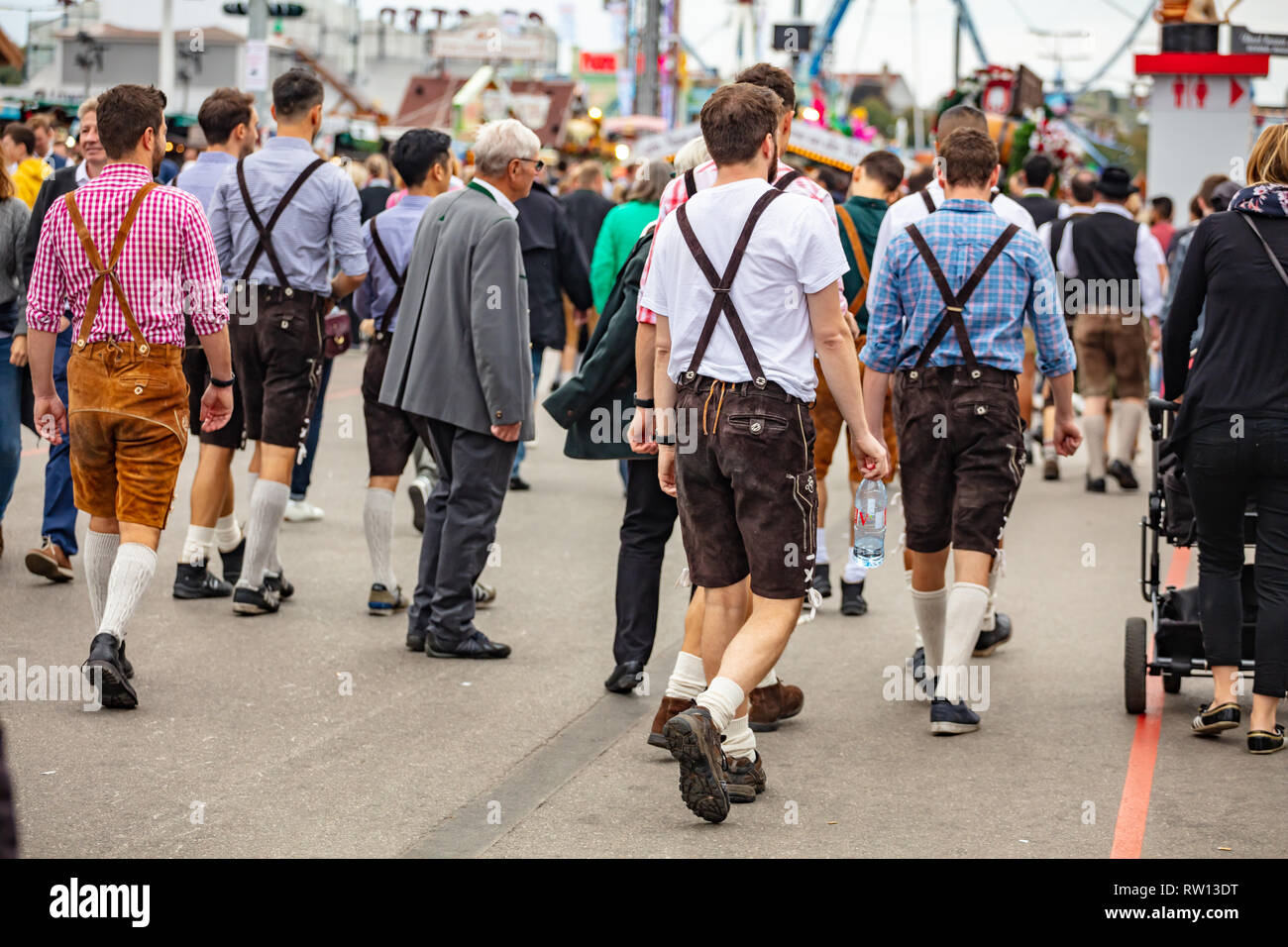 October 7, 2018. Munich, Germany, Oktoberfest, Group of young men in traditional costumes walking among the crowd, back view Stock Photo